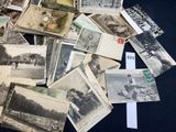 a pile of old photographs on a table with a lot of them