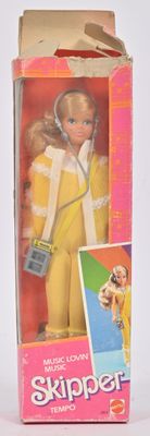poupée Barbie dans une boîte, avec un casque audio et un téléphone portable