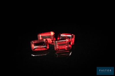 trois cubes en verre rouge posés sur une surface noire
