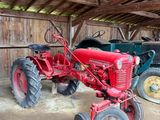 deux vieux tracteurs dans une grange au toit en bois