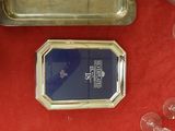 a silver tray with a blue lid and a silver tray with wine glasses on a red table cloth