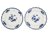two blue and white plates with flowers on them on a white surface