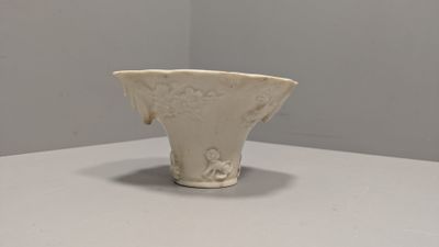 un vase blanc posé sur une table blanche dans une pièce