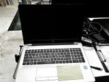 un ordinateur portable posé sur un bureau, à côté d'un stylo et d'une feuille de papier
