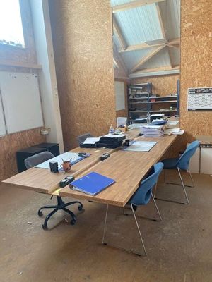 une pièce dans laquelle se trouvent une table, des chaises et un miroir