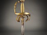 a close up of a sword with a gold handle on a black background