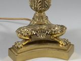 a gold lamp that is on a stand with a cord