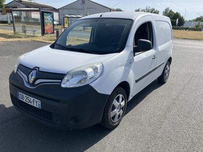 the small white van is parked on the side of the road