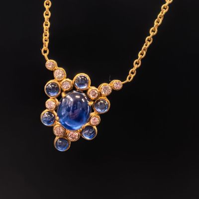 un collier en or orné d'un saphir bleu et de diamants