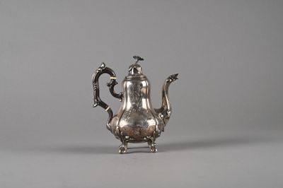 an antique silver teapot with a bird on the top of it