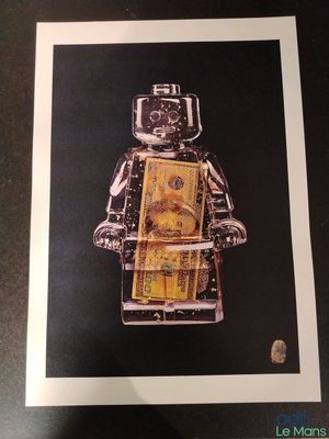 photo encadrée représentant un bonhomme Lego tenant une liasse de billets