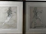 two framed drawings of a man and a woman on the wall