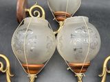 three antique wall sconces with etched glass and brass accents