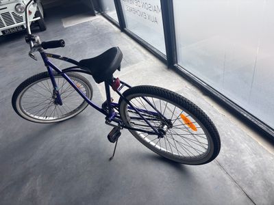 a purple bicycle parked in front of a building