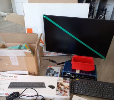 un bureau sur lequel se trouvent un clavier, une souris, un écran et d'autres objets