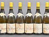 six bottles of wine lined up in a row on a table