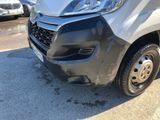 the front end of a silver van parked in a parking lot