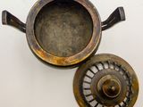 an image of a metal pot with a lid sitting on a white surface