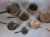 several pots and pans are lined up on a table