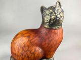 an orange and black cat figurine sitting on top of a white surface