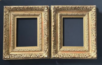 two gold frames on a blue wall with a black background