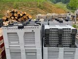 plusieurs caisses en bois empilées les unes sur les autres près d'un tas de bûches
