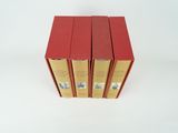 three red books are stacked on top of each other on a white surface