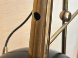 a black and gold lamp with a metal pole on it