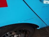 a close up of a blue car with a red sticker on it