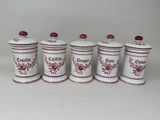 quatre bidons rouges et blancs ornés de fleurs rouges