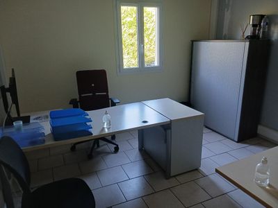 un bureau avec une chaise et un réfrigérateur dans la chambre