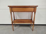 an old wooden table with a shelf on top of it