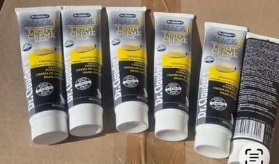 cinq tubes de dentifrice et une brosse à dents posés sur une table