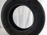 a close up of a tire on a white surface with a curtain in the background