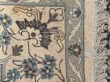 a close up of a rug with a bird and flowers on it