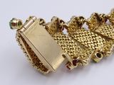 an image of a close up of a gold bracelet on a white surface