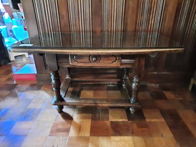 une table en bois avec un plateau en verre posée sur un parquet en bois massif