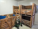 Plusieurs caisses en bois sont empilées les unes sur les autres dans une pièce