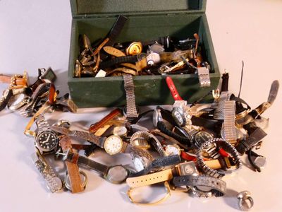 a green box filled with lots of different types of watches