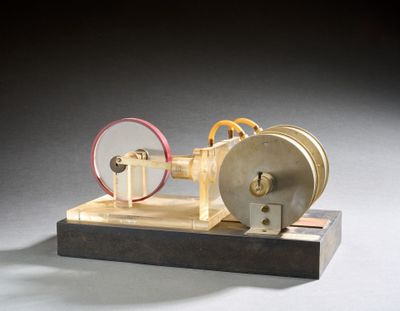 une petite maquette de machine à vapeur posée sur un socle