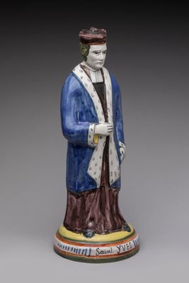 statue d'un homme vêtu d'une robe bleue et d'un chapeau, tenant une canne