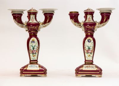 une paire de bougeoirs rouges et dorés ornés de motifs floraux