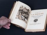 quelqu'un tient un livre ouvert dans lequel figure l'image d'une ville
