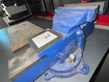un étau bleu posé sur une table dans un atelier