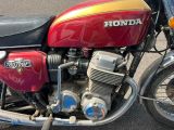 une moto rouge et jaune garée sur le bord de la route