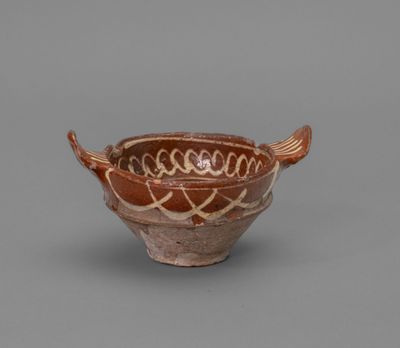 a brown and white bowl sitting on top of a table