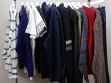 de nombreux pulls suspendus à un portant dans une pièce