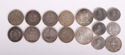 Plusieurs types de pièces de monnaie sont disposés en rangée sur une surface blanche
