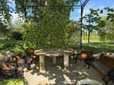 a stone table and benches in a park setting