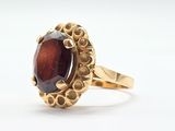 Gros plan sur une bague en or ornée d'une pierre rouge
